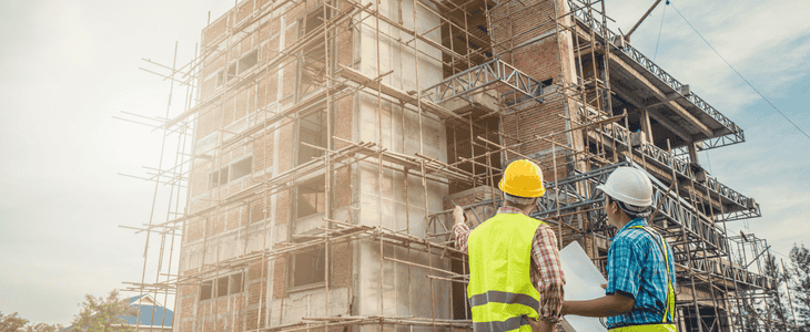 construction crew looks over building blueprint